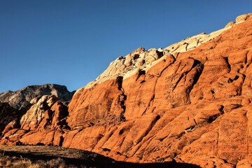 Vibrant Red Sandstone Peaks Rise Majestically Against Azure Skies in Red Rock Canyon's Ancient Desert Embrace, Nevada