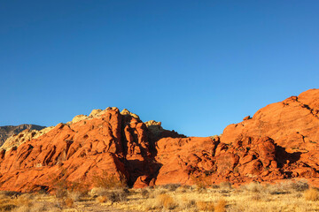 Vibrant Red Sandstone Peaks Rise Majestically Against Azure Skies in Red Rock Canyon's Ancient Desert Embrace, Nevada