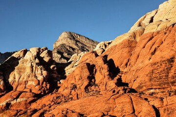 Vibrant Red Sandstone Peaks Rise Majestically Against Azure Skies in Red Rock Canyon's Ancient Desert Embrace, Nevada