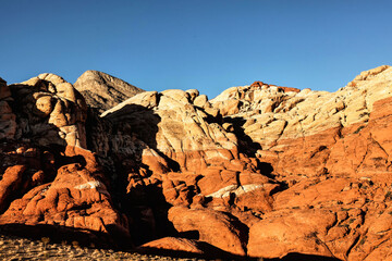 Vibrant Red Sandstone Peaks Rise Majestically Against Azure Skies in Red Rock Canyon's Ancient Desert Embrace, Nevada