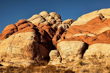 Vibrant Red Sandstone Peaks Rise Majestically Against Azure Skies in Red Rock Canyon's Ancient Desert Embrace, Nevada