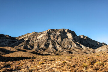 Majestic Crimson Sandstone Spires Pierce Azure Nevada Skies, Unveiling Ancient Desert Layers in Red Rock Canyon's Timeless, Sun-Drenched Embrace