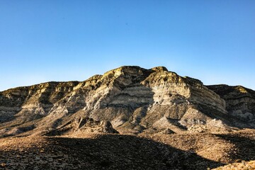 Majestic Crimson Sandstone Spires Pierce Azure Nevada Skies, Unveiling Ancient Desert Layers in Red Rock Canyon's Timeless, Sun-Drenched Embrace