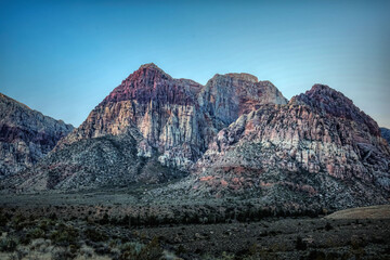 Majestic Crimson Sandstone Spires Pierce Azure Nevada Skies, Unveiling Ancient Desert Layers in Red Rock Canyon's Timeless, Sun-Drenched Embrace