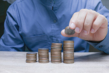 Business growth and savings investment concept with hand stacking coins in ascending order for...