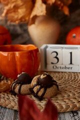 Traditional aesthetics Halloween fall cookies in shape of spider and cup of tea in shape of pumpkin near 31 of October on calendar