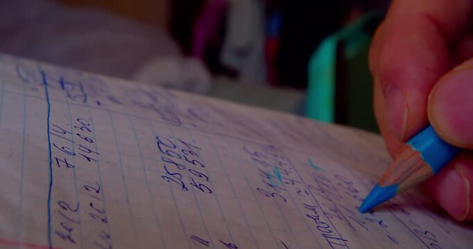 Close-up shot of hand coloring numbers on paper with blue pencil, emphasizing precision and focus in paperwork