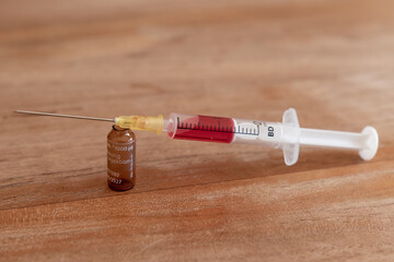 Aufgezogene Spritze mit rotem Serum 