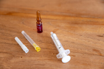 Impfstofffläschchen und Injektionsspritze auf Holztisch