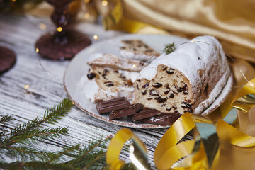 Atmospheric Christmas stollen and chocolate close up. Holidays decorations. Aesthetic traditions background. Table setting.