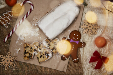 Christmas stollen - traditional holidays bread, gingerbread cookies, candy cone stick, tangerines flat lay. Hot beverage with marshmallow. Festive Christmas Dinner. Christmas traditions food