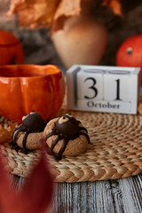 Aesthetics autumn Halloween cookies in shape of spider and cup of tea in shape of pumpkin near 31 of October on calendar