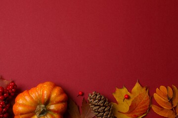 An autumn scene framed by colorful leaves and seasonal elements on a deep red background