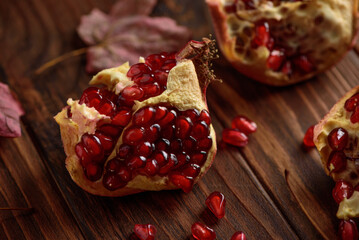Pomegranate with Autumn Leaves on Dark Wooden Background