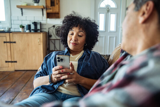 Middle aged couple using a smartphone at home
