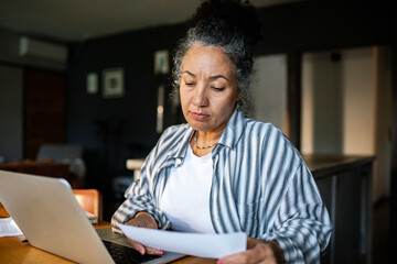 Mature woman working on her finances at home