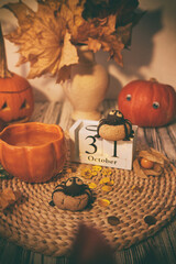 Traditional autumn Halloween cookies in shape of spider and cup of tea among pumpkins. 31 of October on calendar