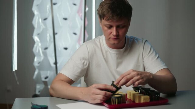 Agricultural technician placing rockwool growing cubes into net pots, preparing plant seeds for modern hydroponic indoor vertical farm, focusing on sustainable and food cultivation, slow motion