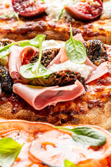 An appetizing Italian pizza topped with mortadella, fresh burrata cheese, wild morel mushrooms, and baby spinach.An Italian pizza with mortadella, creamy burrata cheese, and morel mushrooms on a rusti