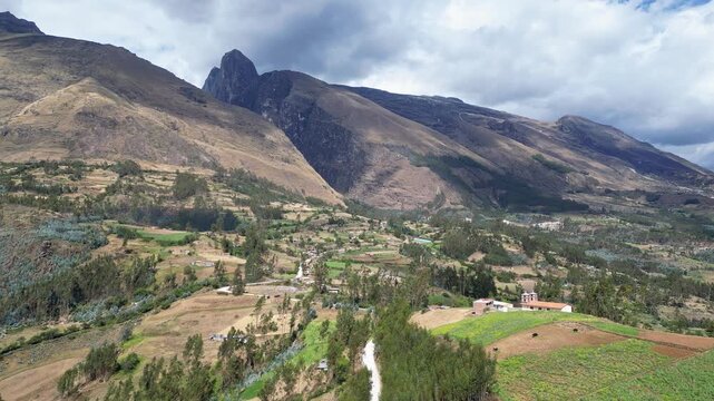 Huaraz, Peru: Drone footage of the road heading to Laguna Paron in Huaraz, Peru with tilt up and forward motion revealing the dramatic valley closed to the huascaran national park on a cloudy day. 