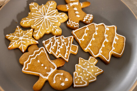 Dark-gray plate on countertop showing gingerbread cookies with white icing shapes, copy space