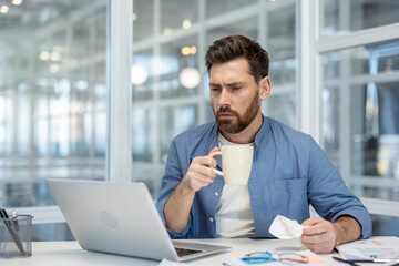 Businessman looking concerned while holding a coffee mug and crumpled paper, feeling stressed from work and experiencing burnout in a modern office environment