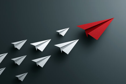 A bold red paper airplane leads a formation of white planes. This symbolizes decisive leadership, being unique, innovation, breaking from the norm, setting direction, and competitive market advantage.