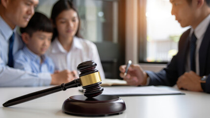 Gavel on table with family and lawyer discussing legal matters, courtroom consultation, judge's hammer, law office consultation, legal advice, justice concept, family law, decision making