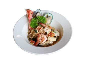 Delicious seafood pasta dish served on a white plate. The pasta is adorned with shrimp, crab, mussels, and fresh herbs