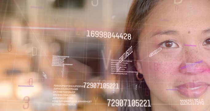 Mid adult Asian woman analyzing floating digital codes overlay in office, copy space