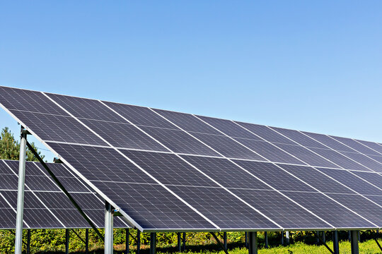 Solar energy. Solar panels positioned in vibrant green field, absorbing sunlight under bright blue sky, highlighting importance of renewable energy solutions and sustainable technology for environment
