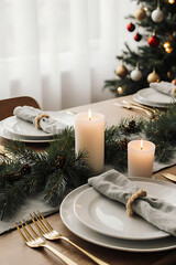Elegant Christmas Table Setting with Gold Cutlery, White Plates and a Lit Candle, Festive Tree in Background

