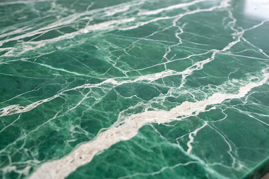 Close-up of polished green marble with white veining — ideal for luxury interiors, architectural surfaces, and natural stone campaigns highlighting texture and elegance. generative ai