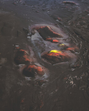 Aerial view of the earth's raw, molten core bleeding into the stark, black landscape, Skaft&aacute;rhreppur, Iceland.
