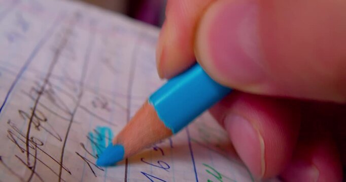 Close-up shot of hand coloring numbers on paper with blue pencil, emphasizing precision and focus in paperwork