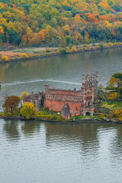 Aerial view of Bannerman Castle, an abandoned military surplus warehouse on Pollepel Island, sits amidst the Hudson River surrounded by autumn foliage, Beacon, New York, United States.