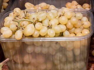 Fresh white seedless grapes in a clear container