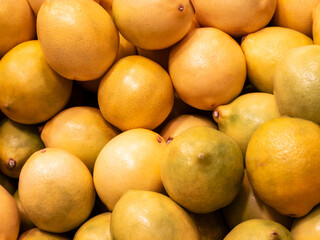 Fresh ripe lemons filling the frame as a vibrant background