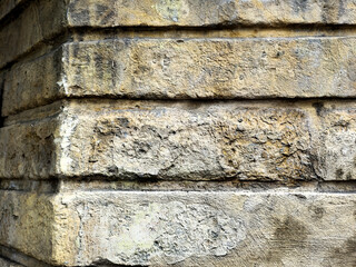 Weathered corner of an old rustic stone block wall