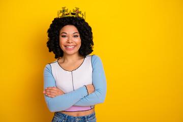 Naklejka na ściany i meble Young woman with curly hair and crown posing confidently against a vibrant yellow background, stylish and cheerful Naklejka na ściany i meble Young woman with curly hair and crown posing confidently against a vibrant yellow background, stylish and cheerful