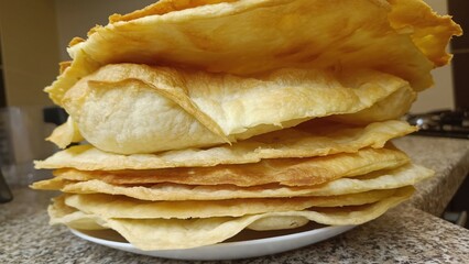 Stack of crispy flatbreads on plate, homemade close-up