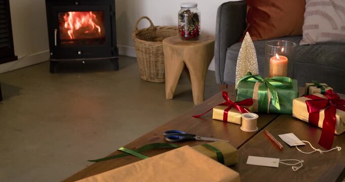 Camera is panning and zooming from stove toward coffee table focusing on ribbons and gift tags
