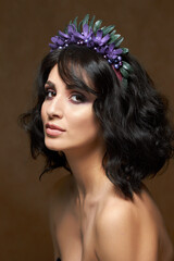 Studio portrait for a beauty advertising campaign. The photo shows a young woman with dark hair. She's barely wearing makeup, her lips are shiny, and her eyes express confidence and calm.