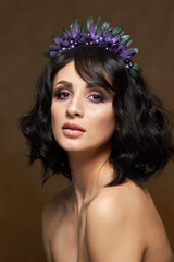 Studio portrait for a beauty advertising campaign. The photo shows a young woman with dark hair. She's barely wearing makeup, her lips are shiny, and her eyes express confidence and calm.