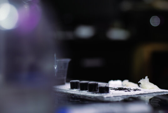 Tattoo ink caps and black pigment on a sterile surface, preparing for body art application in a studio