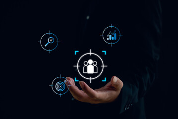 Business and digital marketing concept showing customer targeting, audience analytics, and data-driven strategy. A businessman holds icons representing market insight and performance optimization.