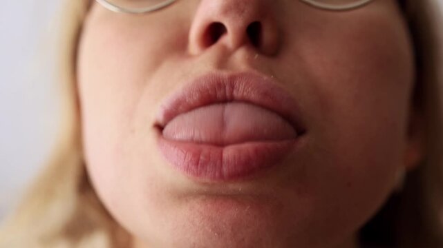 Close-up of female mouth showing tongue, shaking lips over tongue.