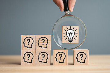 Finding solutions creative idea search concept with magnifying glass and light bulb wooden blocks 100