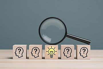 Find the idea concept search for solution with magnifying glass on wooden blocks with lightbulb and question mark