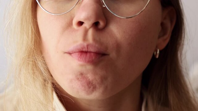 Close-up of female mouth licking lips, showing expression and motion.